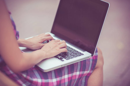 Beautiful young woman using laptop in parkの写真素材