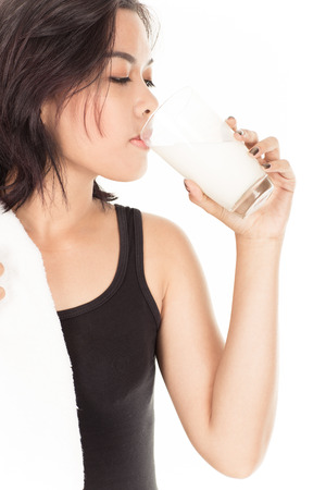 Laughing young woman with a glass of milkの写真素材