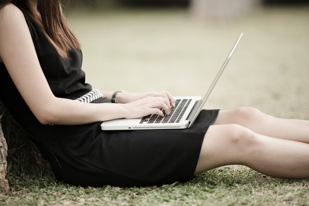 Beautiful young woman using laptop in parkの写真素材