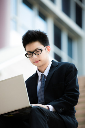young businessman working outside with laptopの写真素材
