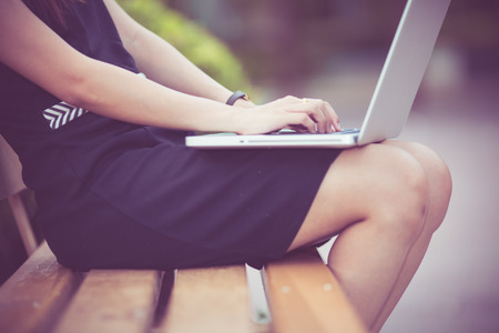 Beautiful young woman using laptop in parkの写真素材