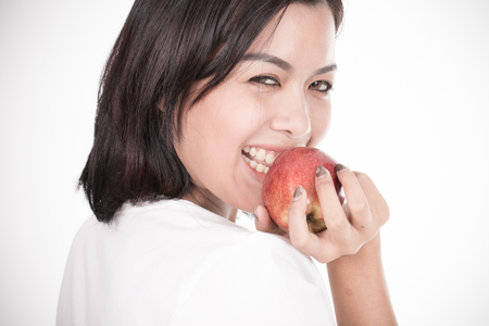 Smiling woman with apple isolated on whiteの写真素材