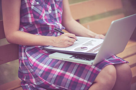 Beautiful young woman using laptop in parkの写真素材