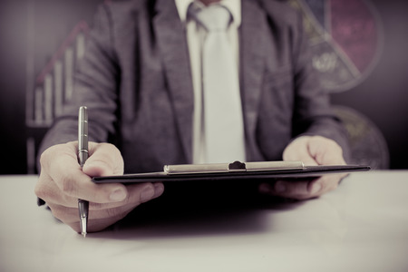 man hand with pen and business reportの写真素材