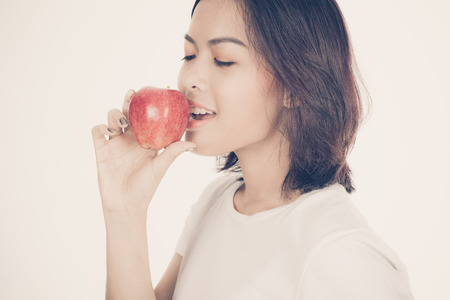Smiling woman with apple isolated on whiteの写真素材