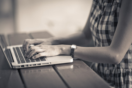 Woman using laptop indoor.close-up hand