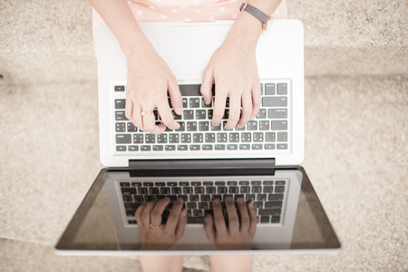 Young woman using laptop on steps outdoors