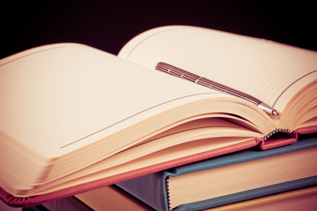 Close-up of open book and pen