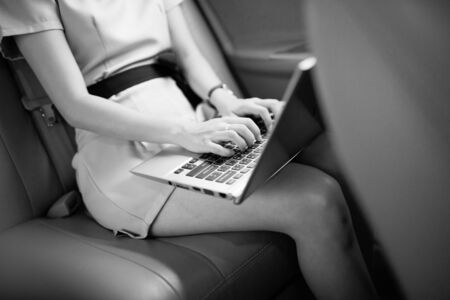 businesswoman with document and laptop in car