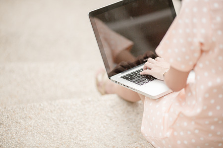 Young woman using laptop on steps outdoorsの写真素材