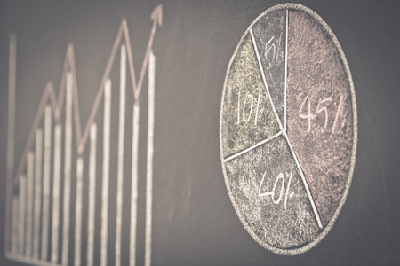 Side view of a businessman's hand. Business graph on a blackboard.の写真素材