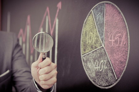 Side view of a businessman's hand. Business graph on a blackboard.の写真素材