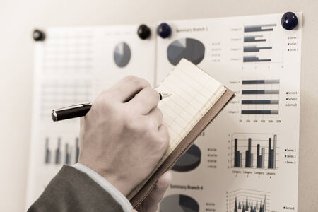 Businessman pointing to flip board with chart in office
