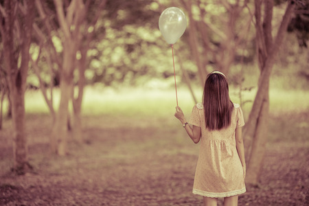 girl with balloons in a fieldの写真素材