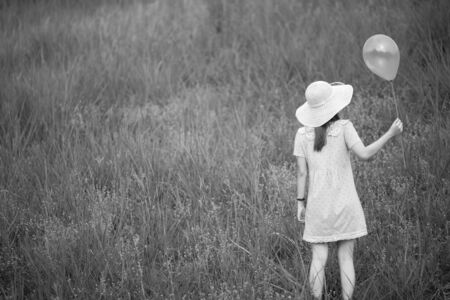 girl with balloons in a fieldの写真素材
