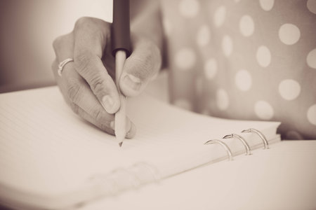 Young female is writing notes and planning her scheduleの写真素材