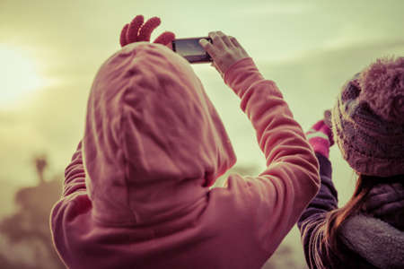 woman hiker taking photo with smart phone at mountain peakの写真素材