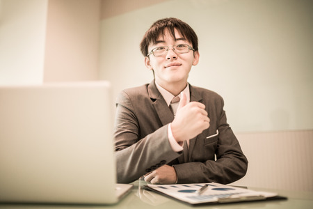Young handsome man using laptop in his office.Asianの写真素材