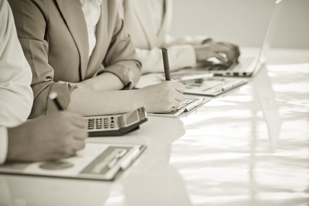 Business people discussing the charts and graphs showing the results of their successful teamworkの写真素材