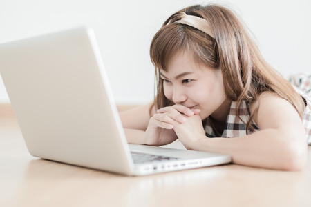 Asian woman using laptop at homeの写真素材