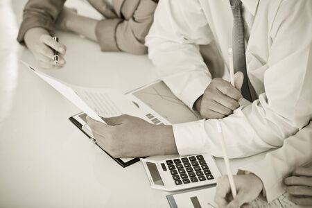 Business people discussing the charts and graphs showing the results of their successful teamworkの写真素材