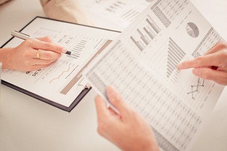 Business people discussing the charts and graphs showing the results of their successful teamwork