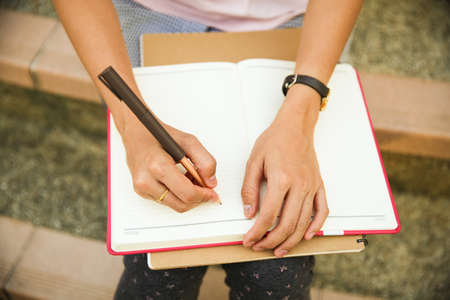 attractive female college student sitting on stairsの写真素材