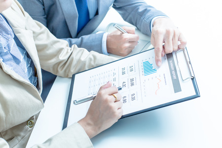 Business people discussing the charts and graphs showing the results of their successful teamworkの写真素材