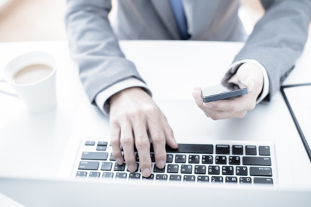 business, technology and internet concept - close up of man hands with coffee and laptop computerの写真素材