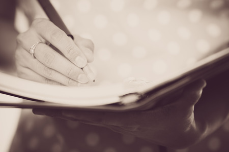 Young female is writing notes and planning her scheduleの写真素材