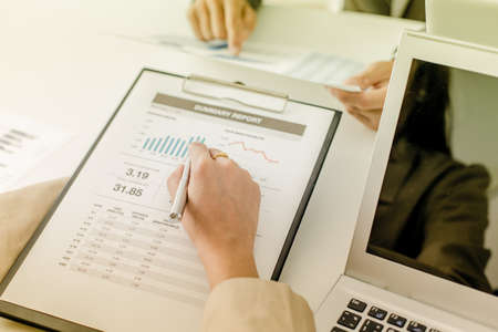 Business people discussing the charts and graphs showing the results of their successful teamworkの写真素材