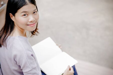 attractive female college student sitting on stairsの写真素材