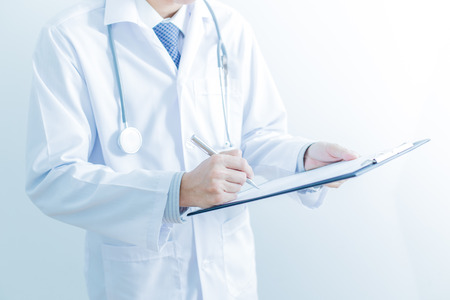Close-up of male hands filling in medical formの写真素材