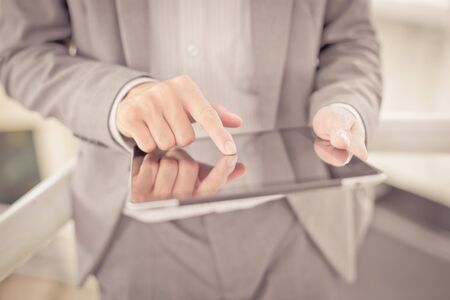 Businessman using electronic tablet pc. He is sitting on a stairs.の写真素材