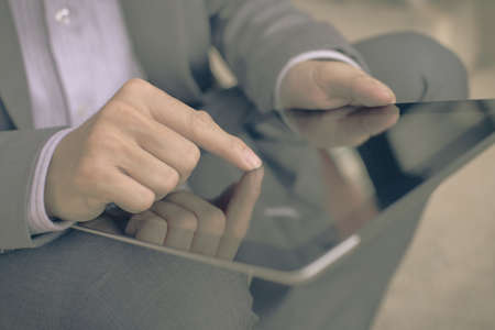 Businessman using electronic tablet pc. He is sitting on a stairs.の写真素材