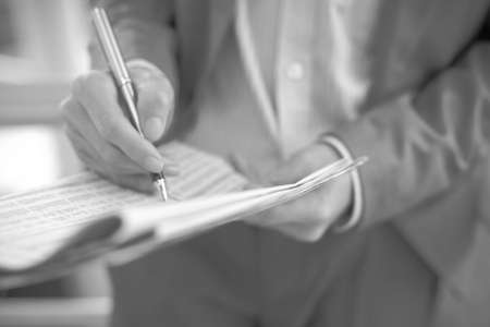 Young business man with newspaper sitting on the stairs.の写真素材