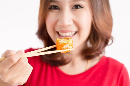 Close-up. young lady eating sushi rollの写真素材