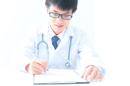 Close-up Of Male Doctor Filling The Medical Formの写真素材