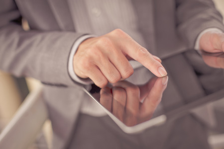 Businessman using electronic tablet pc. He is sitting on a stairs.