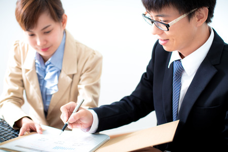 Business people discussing the charts and graphs showing the results of their successful teamworkの写真素材