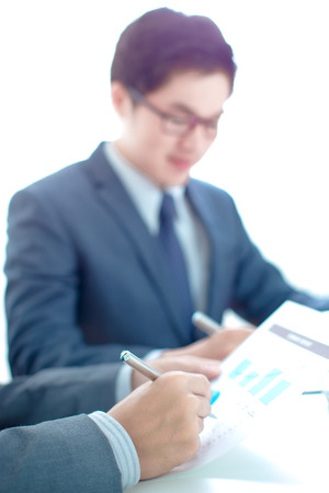 Two businessmen looking at report and having a discussion in office.の写真素材