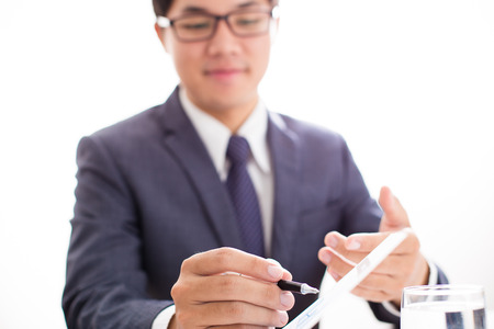 Two businessmen looking at report and having a discussion in office.の写真素材