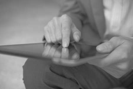 Businessman using electronic tablet pc. He is sitting on a stairs.