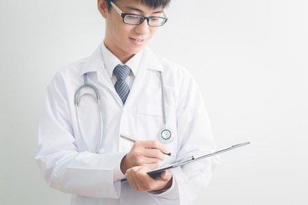 Close-up Of Male Doctor Filling The Medical Formの写真素材