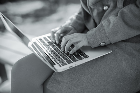 Young woman using laptop on steps outdoorsの写真素材