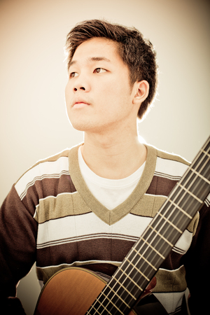 Practicing in playing guitar. Handsome young men playing guitarの写真素材