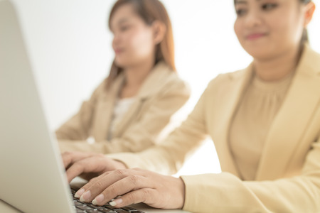 Two Pretty Smiling Businesswomen Discussing the Business using Laptop Device.の写真素材