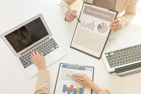 Business people discussing the charts and graphs showing the results of their successful teamworkの写真素材