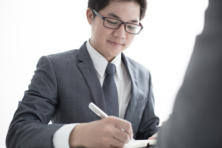 Two businessmen looking at report and having a discussion in office.の写真素材