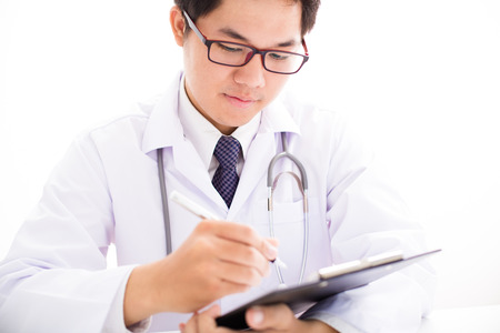 Close-up Of Male Doctor Filling The Medical Formの写真素材